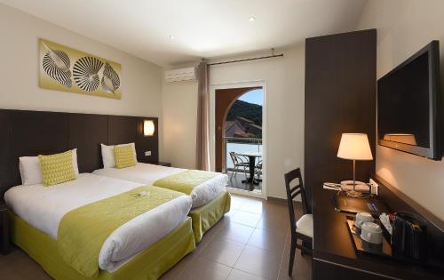 um quarto de hotel com uma cama grande e uma varanda em Hotel U Ricordu & Spa em Macinaggio