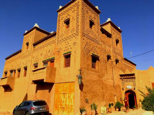 a building with a car parked in front of it at Kasbah Elmehdaoui in Skoura
