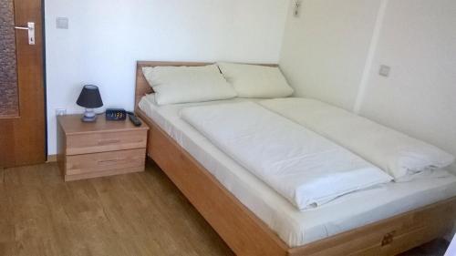 バート・フュッシンクにあるChalet Swiss - App.Nellesのナイトスタンドとベッドサイドシックスが備わる客室のベッド1台分です。
