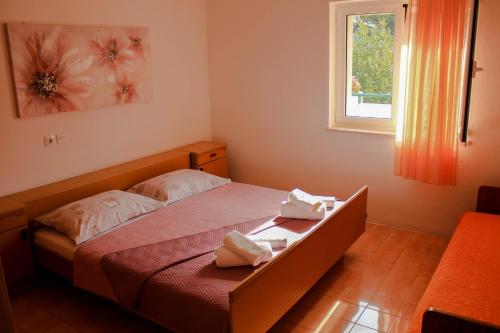 1 dormitorio con 1 cama con 2 toallas en Apartments Pino, en Makarska