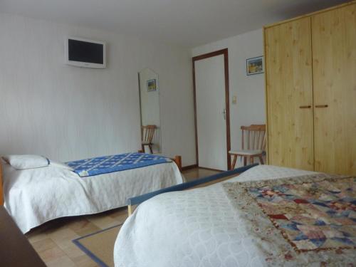 a hotel room with two beds and a tv at Clos de la Natouze in Boyer