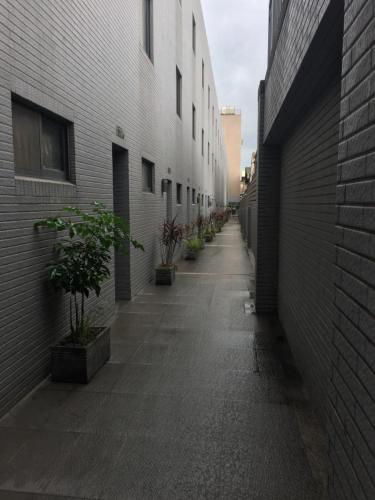 an empty alley between two buildings with potted plants at 長月居 in Taichung
