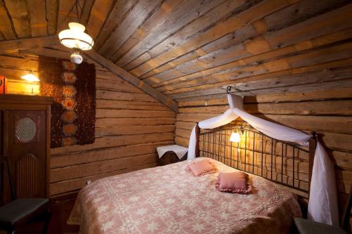 um quarto com uma cama num chalé de madeira em Matkailutila Lahdelma em Pertunmaa
