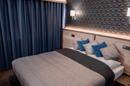 una camera da letto con un grande letto con cuscini blu di Exclusive Pension Vista Mlada Boleslav a Bradlec