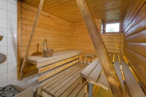 a wooden sauna with a bench and a sink at Matkailutila Lahdelma in Pertunmaa