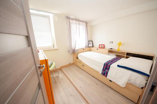 um pequeno quarto com uma cama e uma janela em Daniela House 4 em Anzio