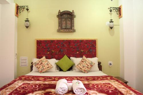 a bedroom with a bed with two slippers on it at Shanti Home in Jaisalmer