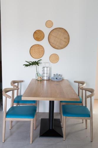 a wooden table with blue chairs and plates on the wall at DeeProm Pattaya Hotel in Pattaya Central