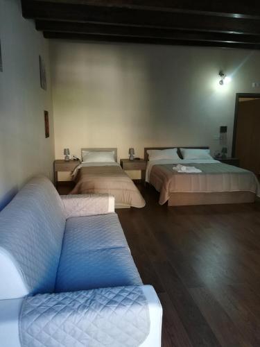 a room with two beds and a couch in it at B&B Nonna Maria in Lamezia Terme