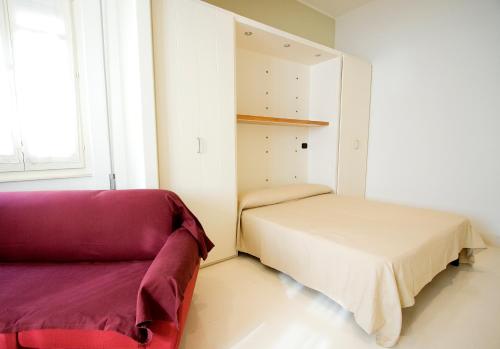 - une petite chambre avec un lit et un canapé dans l'établissement Residence Arco Antico, à Syracuse