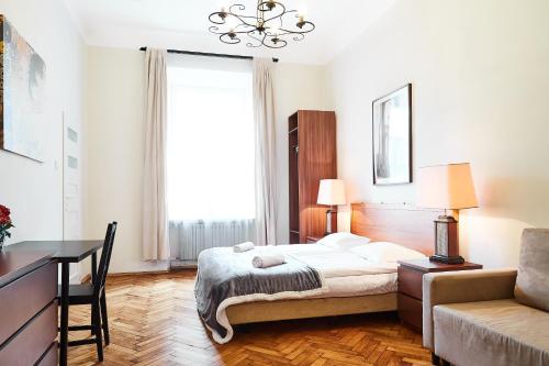 a bedroom with a bed and a desk and a couch at Prestige location apartments Pijarska street in Krakow