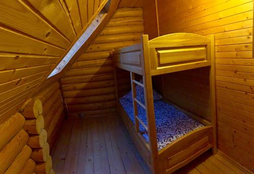 an inside of a wooden cabin with a bunk bed at Рутенія in Svalyava