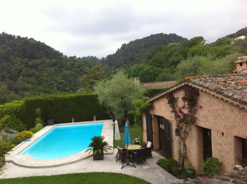 a villa with a swimming pool in front of a house at ABEILLE in Vence