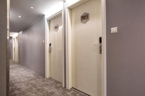 a corridor of a hallway with two elevators in a building at Cityinn Hotel Taipei Station Branch I in Taipei