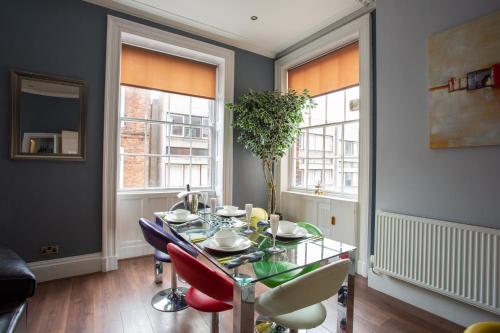a dining room with a glass table and chairs at Most central luxury apartment - sleeps 4 & FREE parking! in Chester