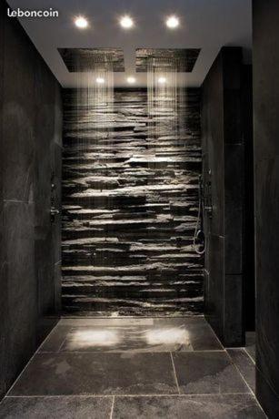 a bathroom with a walk in shower with a stone wall at chambre romantique avec spa privatif in Ferrière-la-Grande