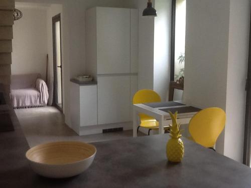 un salon avec une table et des chaises jaunes dans l'établissement Liris Bleu, à Gigean