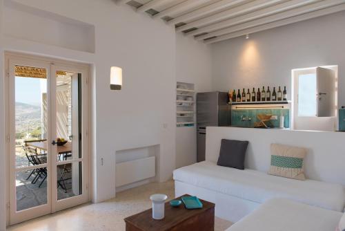 a white living room with a white couch and a table at Katavati - 2 Semi-detached Houses in Apollonia