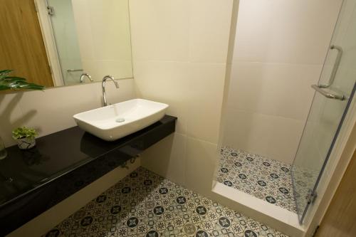 a bathroom with a sink and a shower at DeeProm Pattaya Hotel in Pattaya Central