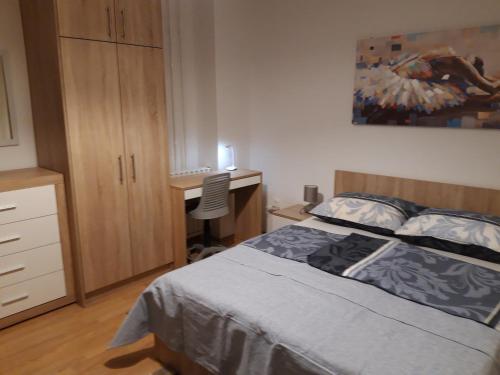 a bedroom with a bed and a desk at Apartman Centros in Osijek