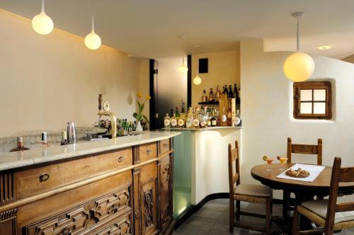 a kitchen with a bar and a dining room with a table at Miramonti Park Hotel in Bormio
