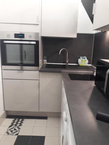 a kitchen with white cabinets and a sink at Palm beach Cannes Azur in Cannes