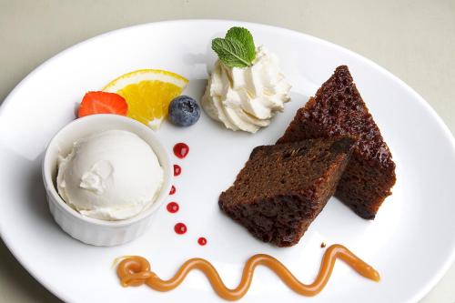 a white plate with a piece of cake and ice cream at The Rusty Mackerel in Teelin
