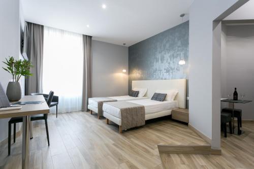 a bedroom with a bed and a table and a desk at ApartHotel Durini in Milan