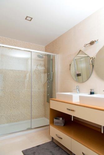 a bathroom with a shower and a sink and a mirror at Casa do Largo do Cruzeiro in Vouzela