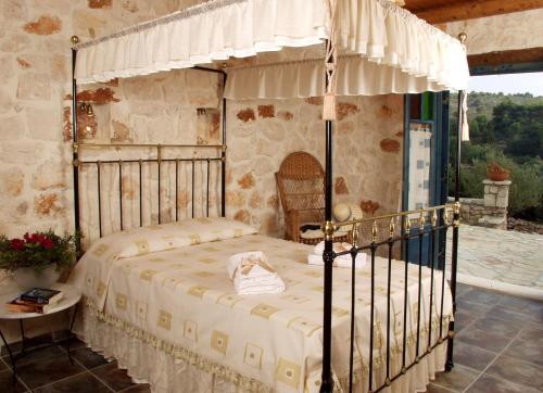 ein Schlafzimmer mit einem Himmelbett in der Unterkunft Revera Traditional Stone Villas, Apartments & Studios in Kerion