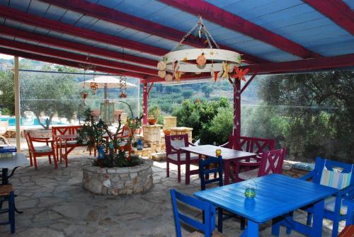 a patio with blue tables and chairs at Revera Traditional Stone Villas, Apartments & Studios in Keri