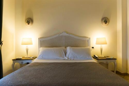 a bedroom with a large bed with two lamps at Tenuta D'Amore in San Mango Piemonte