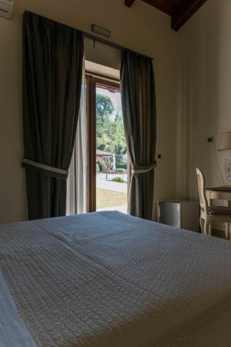 a bedroom with a bed and a large window at Tenuta D'Amore in San Mango Piemonte