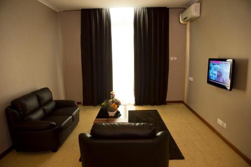 a living room with two leather chairs and a tv at Seascape Hotel in Dar es Salaam