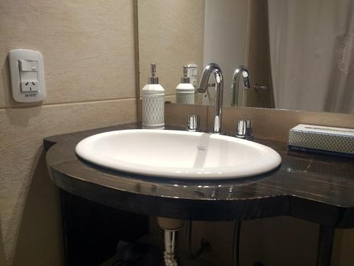 a white sink in a bathroom with a mirror at Departamentos Patagonia in San Carlos de Bariloche