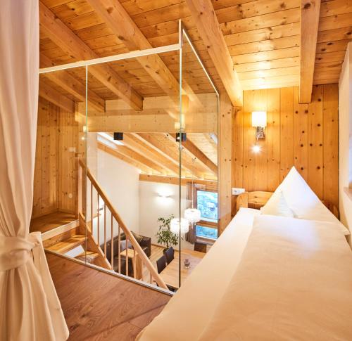 uma cama grande num quarto com paredes de madeira em Tirolerhof - Appartmenthaus em Kaunertal
