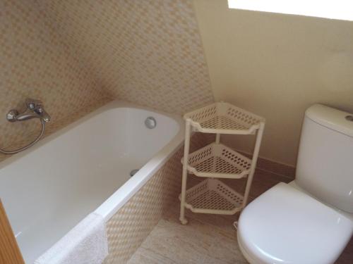 een badkamer met een wit bad, een toilet en een wastafel bij Kraina Szczęśliwości in Zawoja