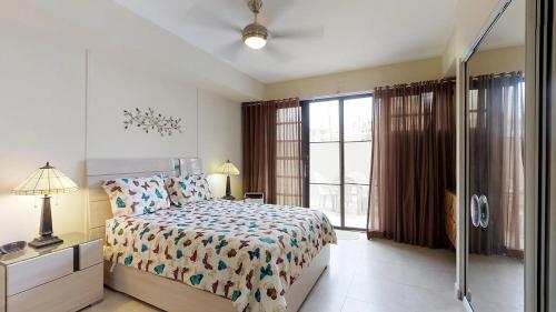 a bedroom with a bed and a large window at Crescent Cove 87 at Palmas in Humacao
