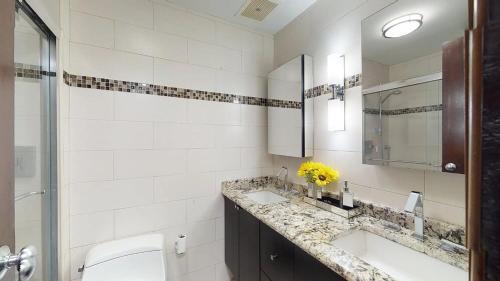 Baño blanco con lavabo y espejo en Crescent Cove 87 at Palmas, en Humacao
