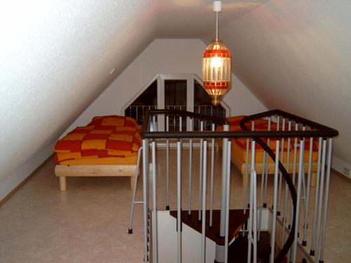 フライブルクにあるFH Alfredの階段、ベッド、シャンデリアが備わる客室です。