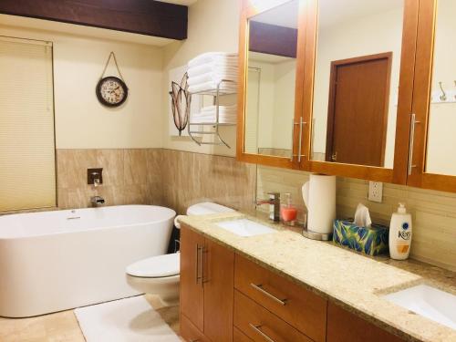 a bathroom with a tub and a toilet and a sink at Garden Bridge House in Sechelt