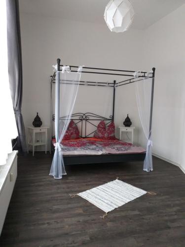 クヴェードリンブルクにあるModern Marakeschのベッドルーム1室(天蓋付きベッド1台、赤い枕付)