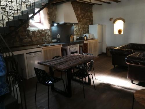 BAVIECA-MARIMEDRANO 12 في مديناسيلي: مطبخ فيه طاولة وكراسي خشبية