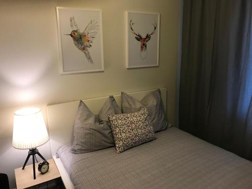 - une chambre avec un lit doté d'une lampe et de photos murales dans l'établissement Apartament Bulwary Warty, à Śrem