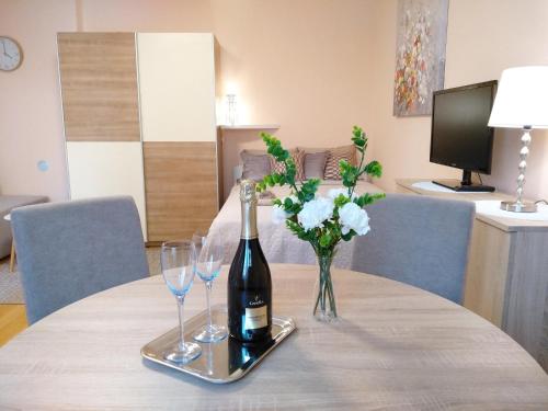 una bottiglia di vino e due bicchieri su un tavolo di Sunray Studio Apartment a Zagabria
