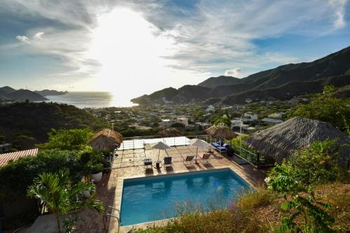 ein Schwimmbad an der Seite eines Hauses mit Bergen in der Unterkunft Casa Relax - Adults Only in Taganga