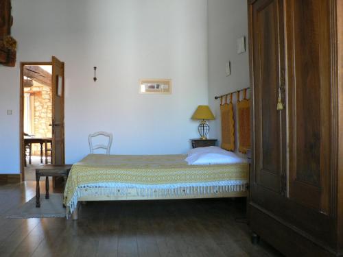 a bedroom with a bed with a wooden headboard at Chambres d'hôtes Domaine de Beaupré in Narbonne