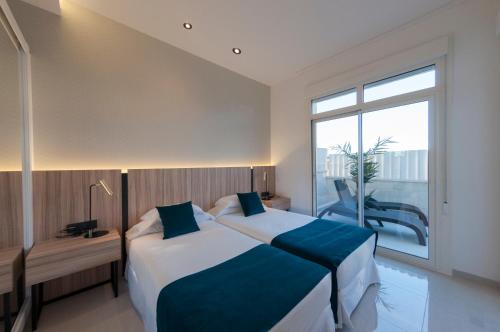 a bedroom with two beds and a large window at Apartamentos La Laguna II Luxury Apartments in Ciudad Quesada