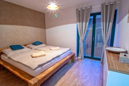 sypialnia z łóżkiem i dużym oknem w obiekcie Horský Apartmán Klínovec Výhledy 1 w mieście Loučná pod Klínovcem