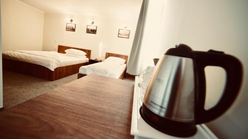 a hotel room with two beds and a tea kettle at Pensiunea Rustic in Hunedoara